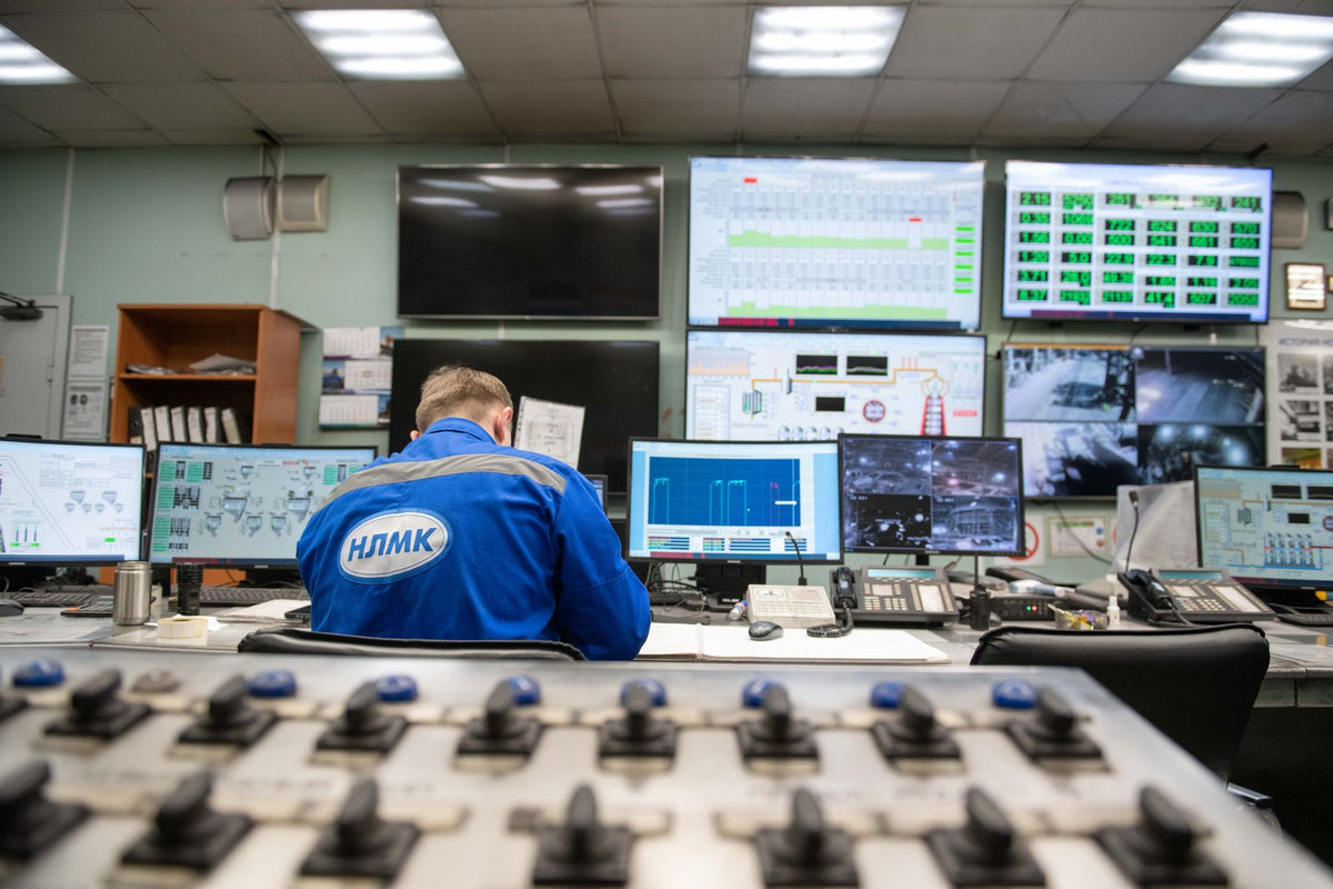 Operator reviewing industrial process information on control-room screens