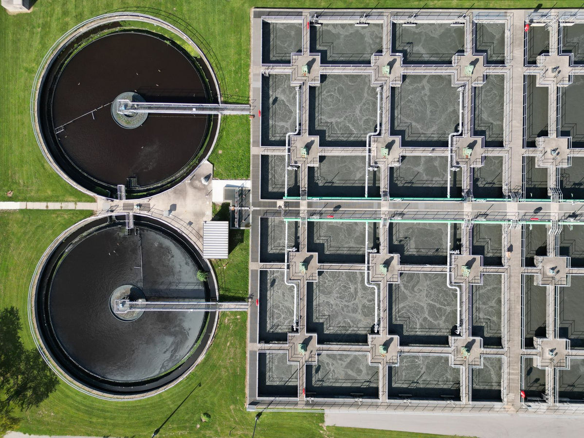 Aerial view of circular tanks and treatment basins at a wastewater treatment plant